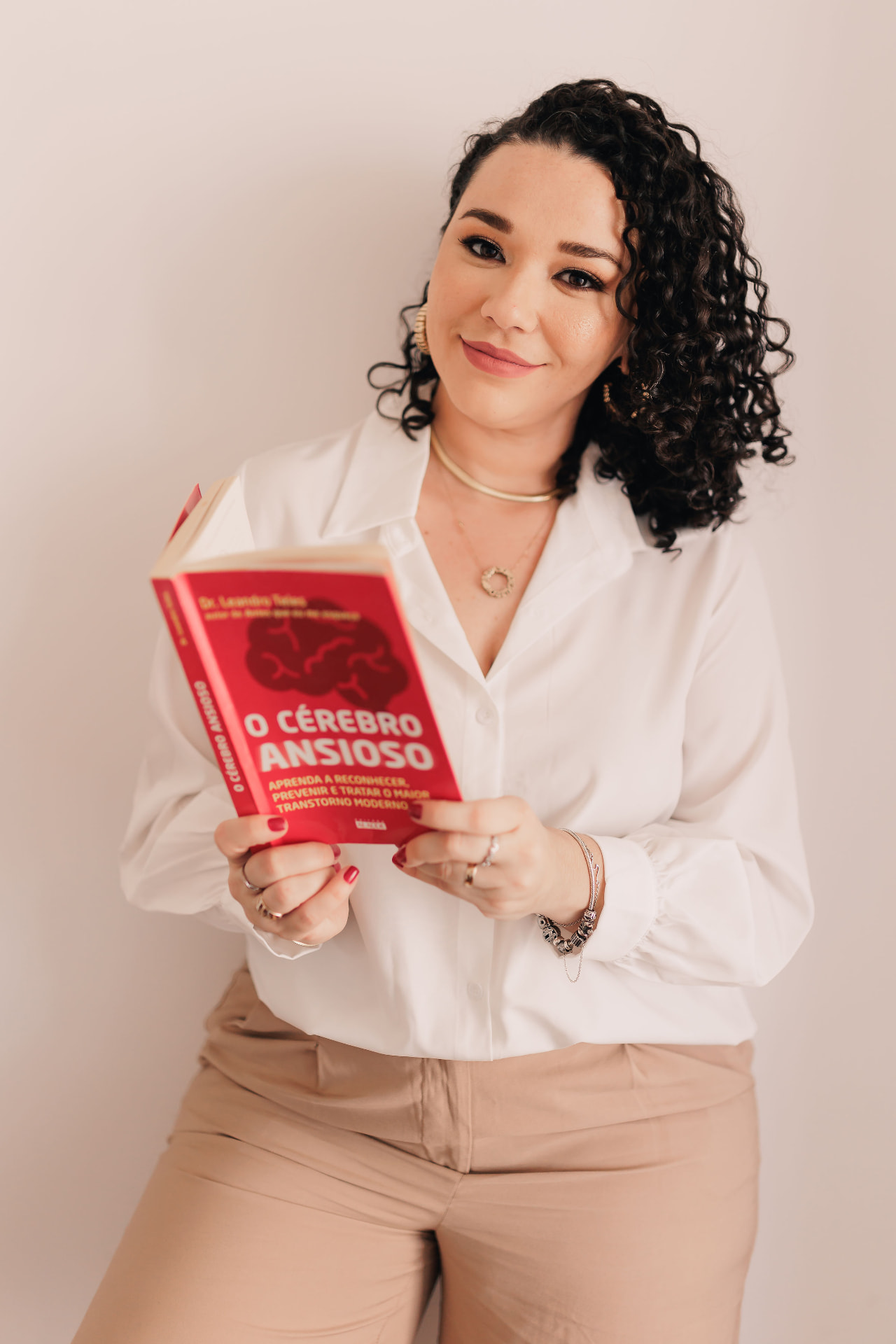 Psicóloga Denise Anjos, idealizadora do Clube, segurando um livro de psicologia